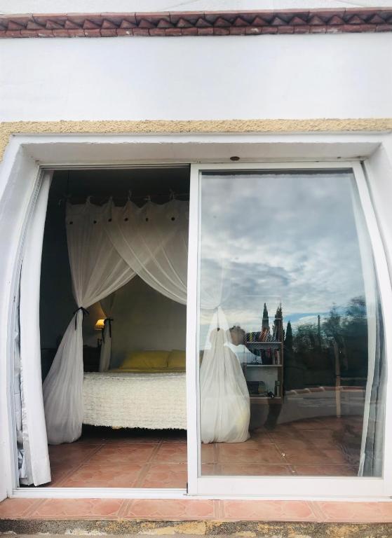 een slaapkamer met een bed in een raam bij Cortijo el Abejaruco in Almuñécar