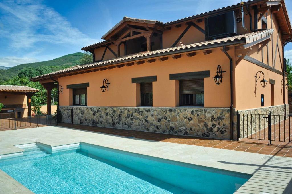 Villa con piscina frente a una casa en El Hojaranzo Casa rural con encanto en Candeleda, en Candeleda