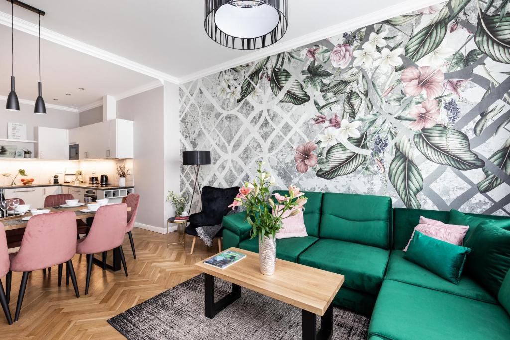 uma sala de estar com um sofá verde e uma mesa em Luxe Living Krakow em Cracóvia