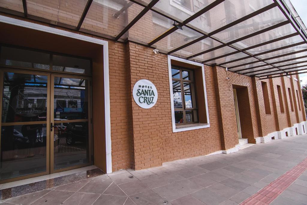 un bâtiment en briques avec un panneau sur son côté dans l'établissement Hotel Santa Cruz, à Santa Cruz do Sul
