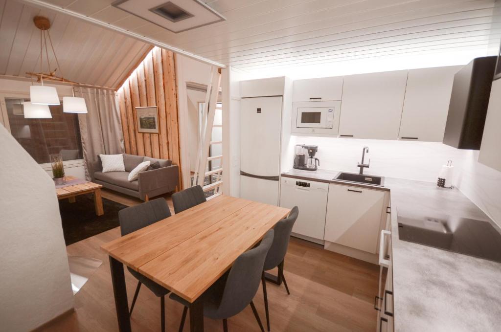 a kitchen and dining room with a wooden table and chairs at Luttokolo, Saariselkä in Saariselka