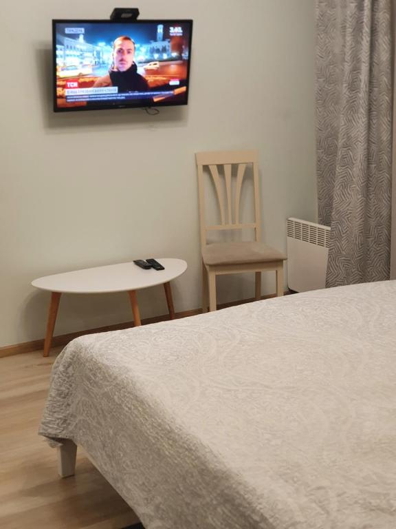 um quarto com uma cama e uma televisão na parede em Квартира-студія em Lutsʼk