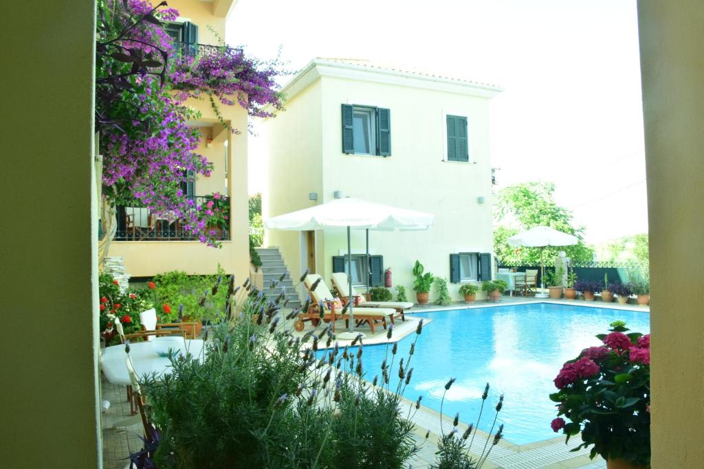 a swimming pool with chairs and umbrellas next to a building at Sparto Village in Meganisi