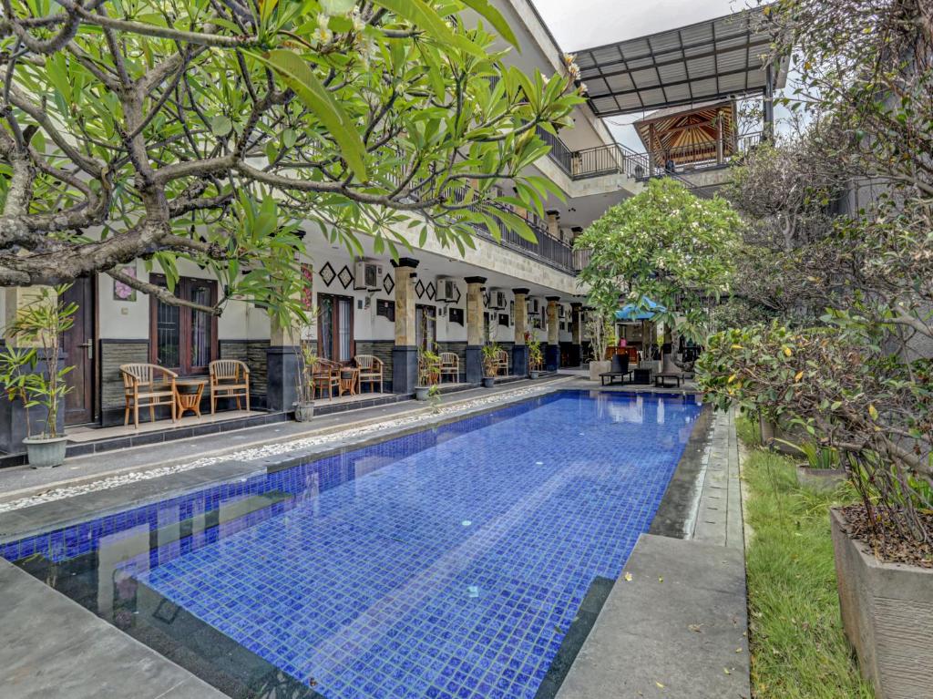 a swimming pool in the courtyard of a building at Super OYO 3904 Kiki Residence Bali in Seminyak