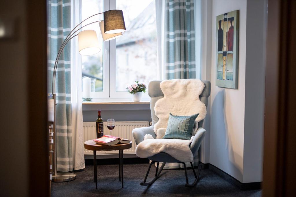 um quarto com uma cadeira, uma mesa e uma janela em Altstadt-Chalet @Conny's em Brilon