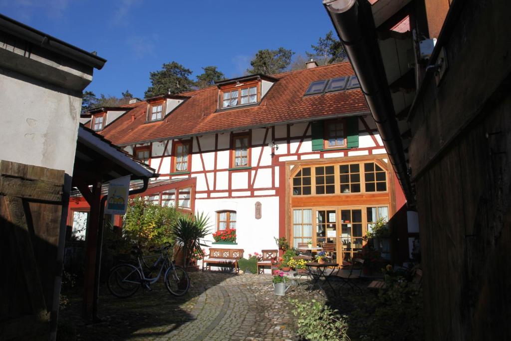 un gran edificio blanco y rojo con un patio en Gästehaus Pfefferle Hotel garni und Ferienwohnungen, en Sigmaringen