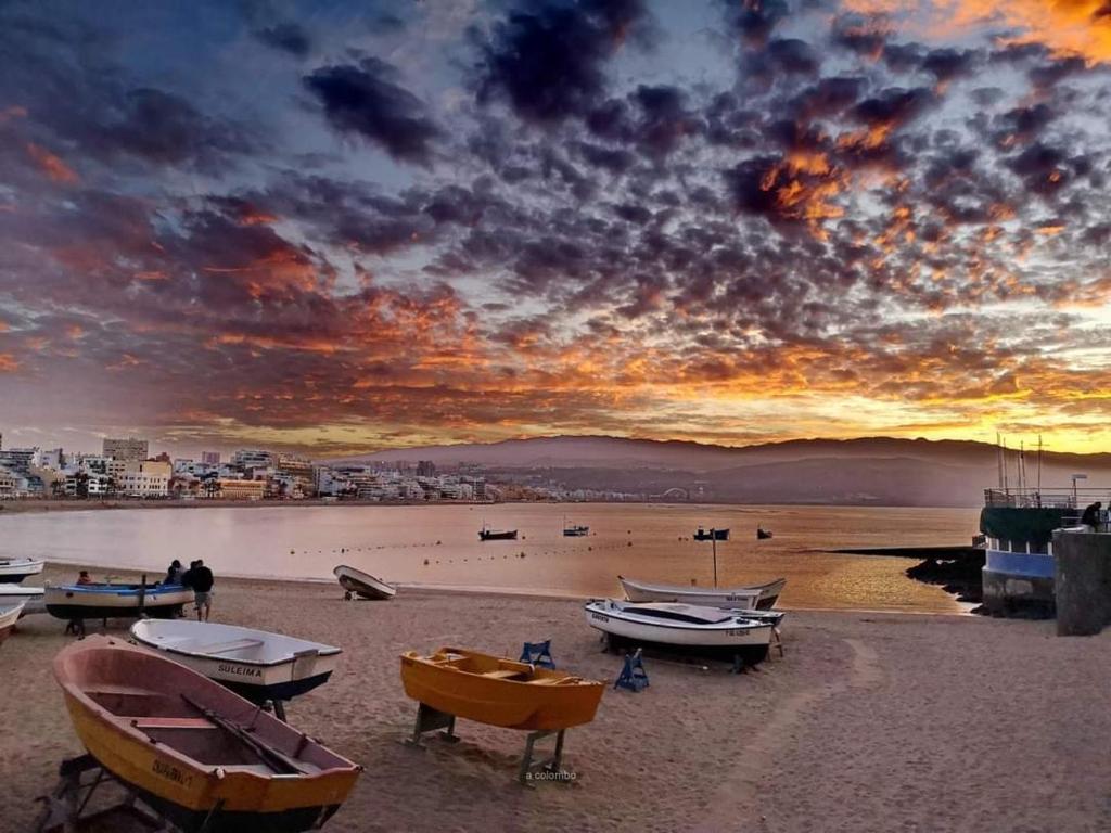 un grupo de barcos en la playa al atardecer en Apartamento Hierro 21-2, en Las Palmas de Gran Canaria