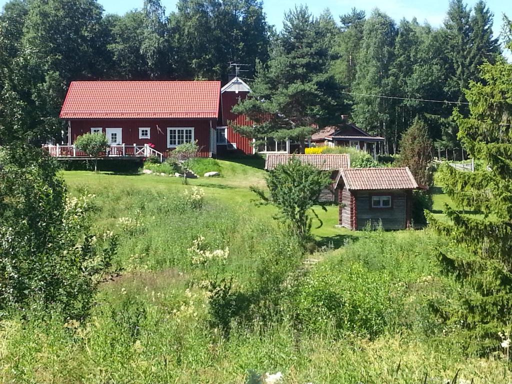 a red house in the middle of a field at Kullsbjörken Bed & Breakfast in Tällberg