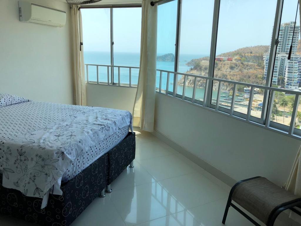 a bedroom with a bed and a view of the ocean at Apartamento En El Rodadero in Santa Marta