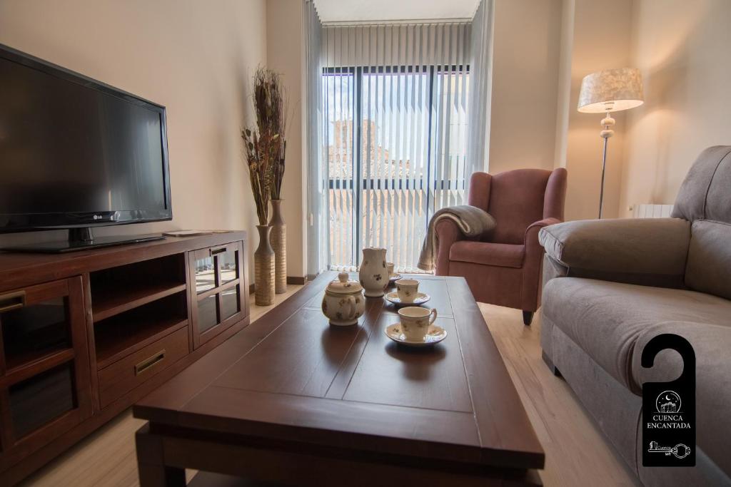a living room with a television and a coffee table at Cuencaloft Noheda in Cuenca
