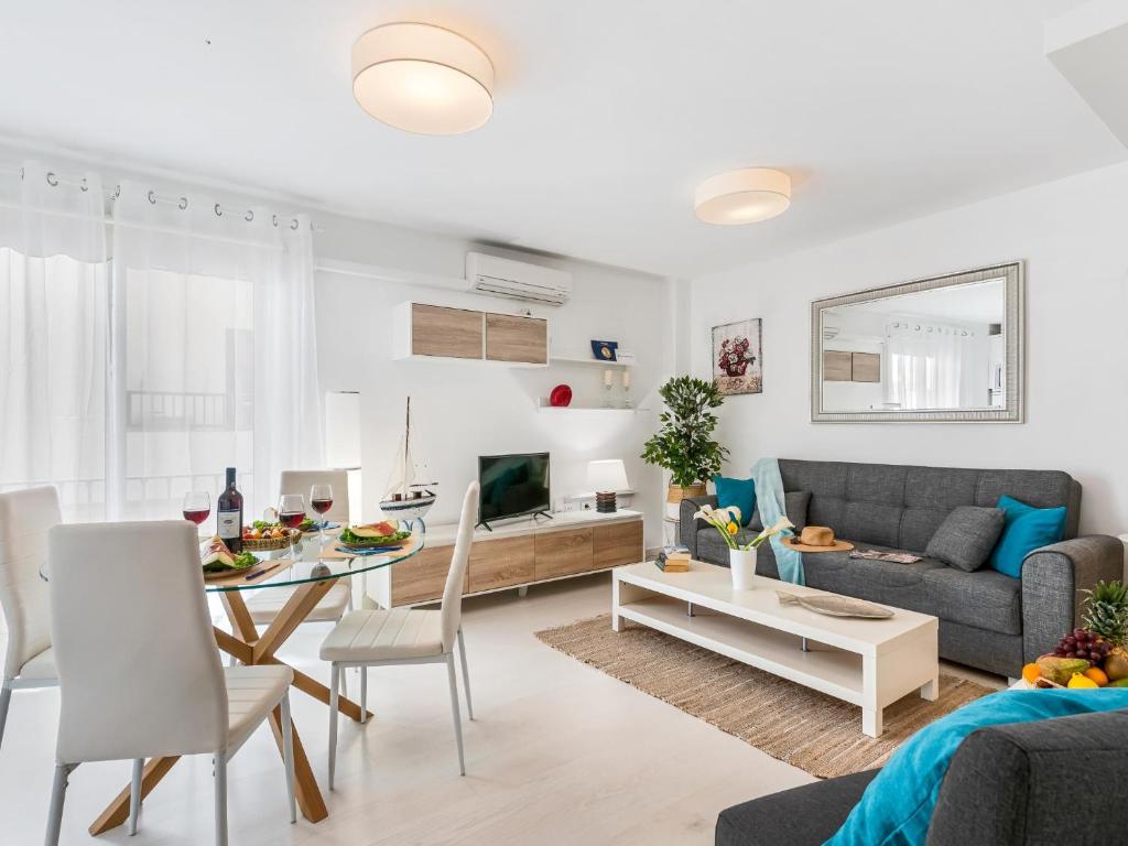 a living room with a couch and a table at 205 Los Cristianos by the beach, center, wifi AC in Arona
