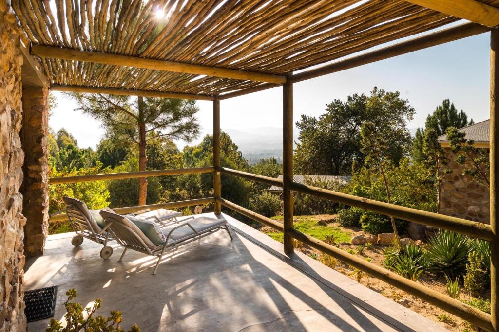 eine Terrasse mit einer Bank und Aussicht in der Unterkunft Amberg Country Estate in Paarl