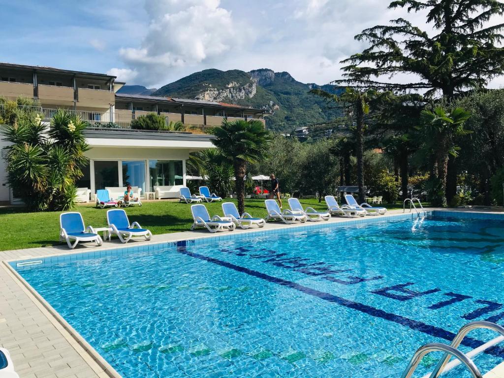 a swimming pool with chairs and a house at Villa Franca in Nago-Torbole