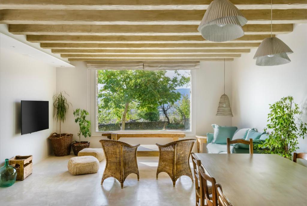 sala de estar con mesa, sillas y ventana grande en OS ORMOS Casa Rural - Apartamentos - Habitaciones, en Espuéndolas