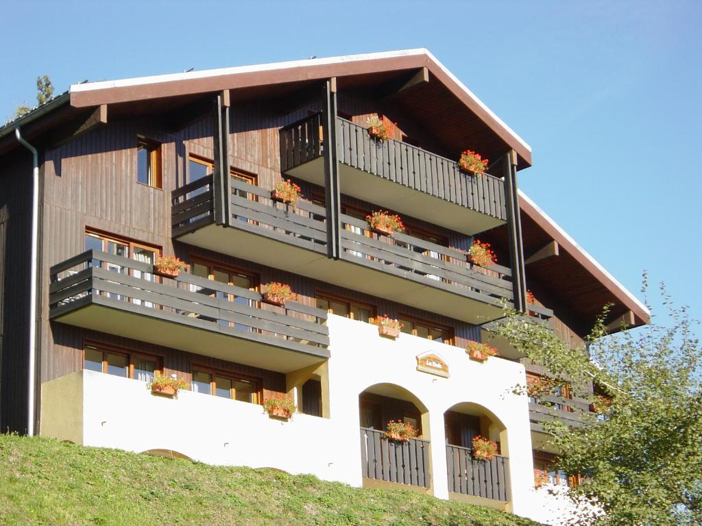 a building with flowers on the balconies of it at Vacancéole - Résidence La Duit in La Léchère