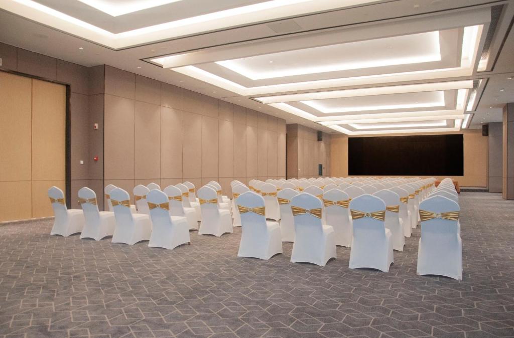 深セン市にあるHoliday Inn Express Shenzhen Haiyuan City by IHGの長いテーブルと椅子のある会議室