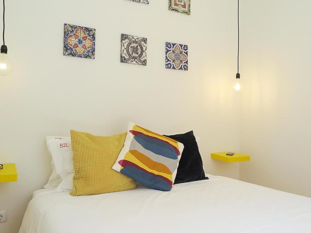 a bedroom with a white bed with pillows on it at Mouraria lovers cozy bright apartment in Lisbon