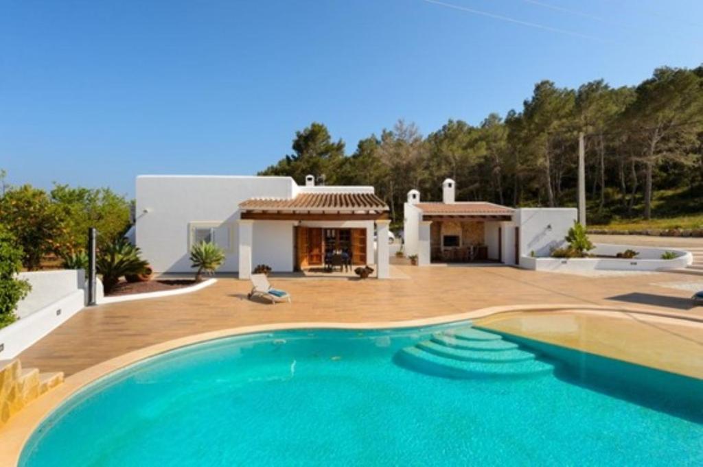 a villa with a swimming pool in front of a house at Can Pepe Pujolet in Santa Gertrudis de Fruitera