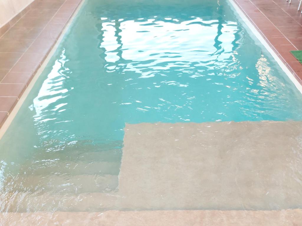 una piscina de agua azul y un suelo de baldosa en Casa El Arrebol Rural, Piscina climatizada, en Los Ángeles de San Rafael