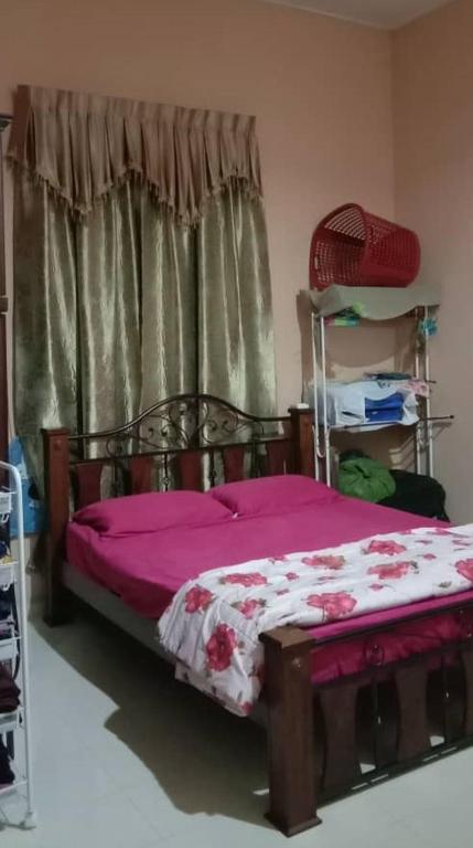 a bedroom with a bed with purple sheets and a window at Bilik Sewa PC (private room) in Kota Bharu