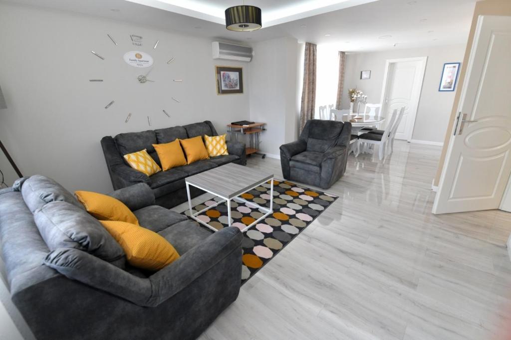 ein Wohnzimmer mit 2 Sofas und einem Tisch in der Unterkunft Family apartman Bijeljina in Bijeljina