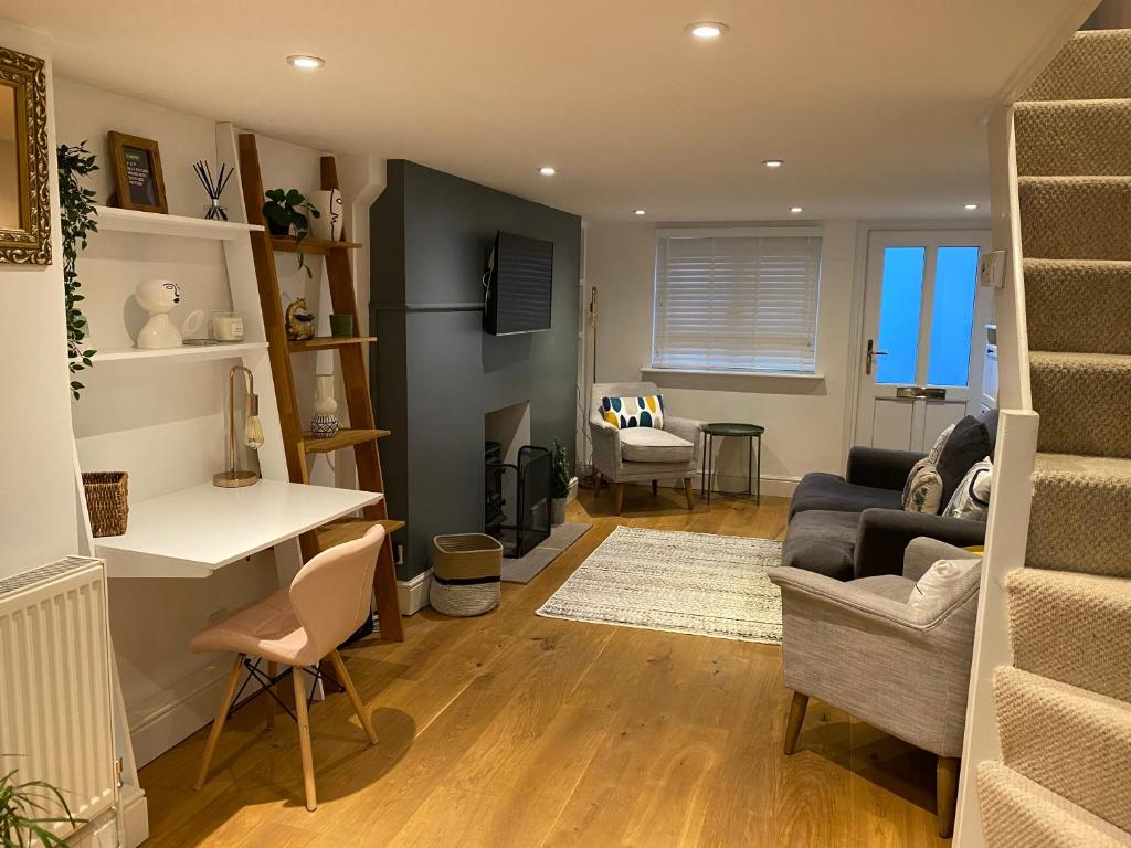 een woonkamer met een bank en een tafel bij Cosy and Contemporary Cottage in Uckfield