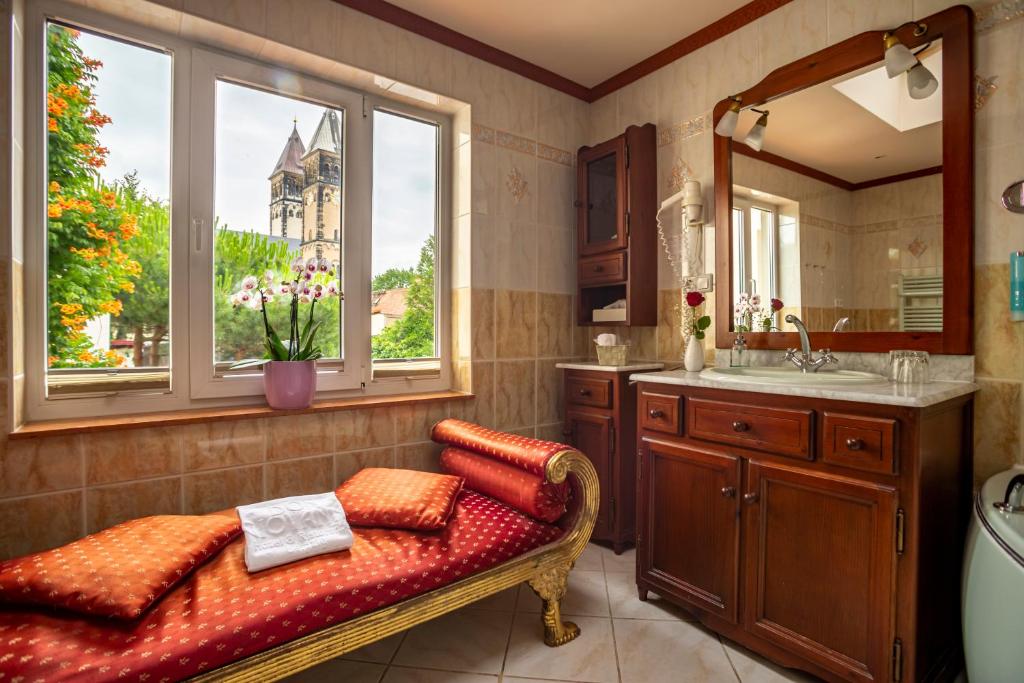 baño con banco, lavabo y espejo en Hotel Don Giovanni, en Leipzig