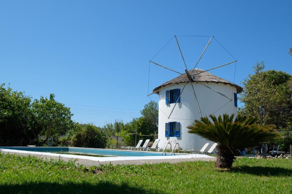 een windmolen naast een zwembad bij Villa Spyridoula studios on the Beach in Sidari