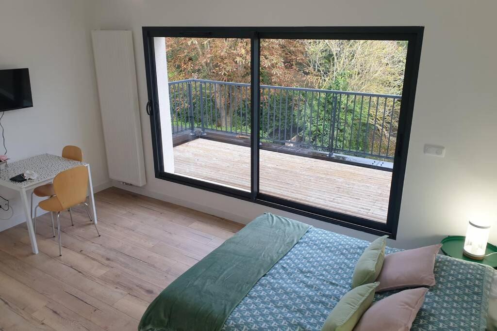 une chambre avec un lit et une grande fenêtre dans l'établissement studio 3 Henriville, à Amiens