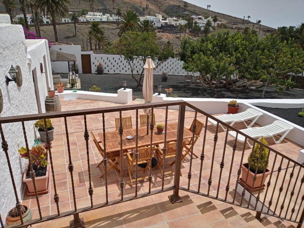 un patio con tavolo e sedie sul balcone. di Casa Maria Dolores a Haría