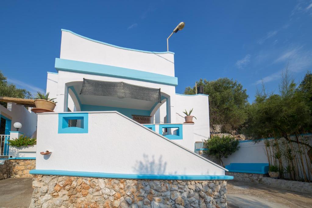 dom z białymi ścianami i niebieskimi akcentami w obiekcie Villa SALENTO2 -doppio terrazzo panoramico vista mare mozzafiato immersa nella natura w mieście Alessano