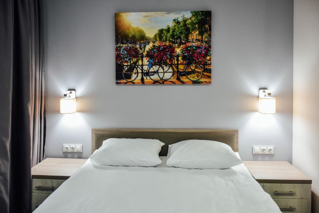 um quarto com uma cama e um quadro na parede em Park Hotel em Nizhyn