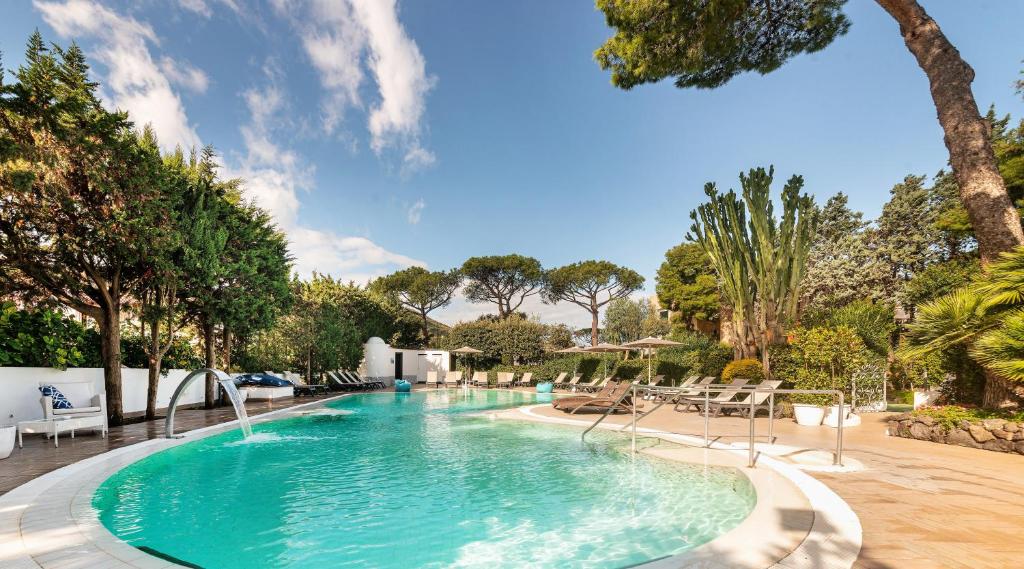 a large swimming pool with chairs and trees at Hermitage Resort & Thermal Spa in Ischia