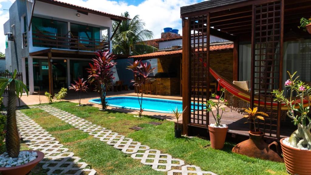 a backyard with a swimming pool and a house at Casa de Praia in Cabedelo