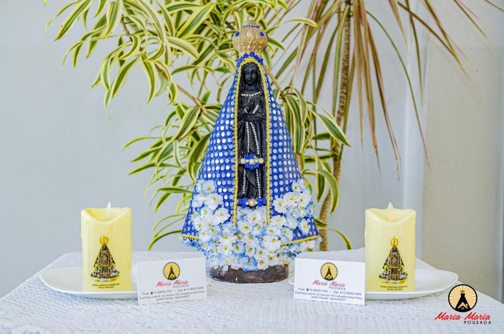 un tavolo con due candele e una torta sopra di Pousada Maria Maria Próximo ao Santuário Nacional a Aparecida