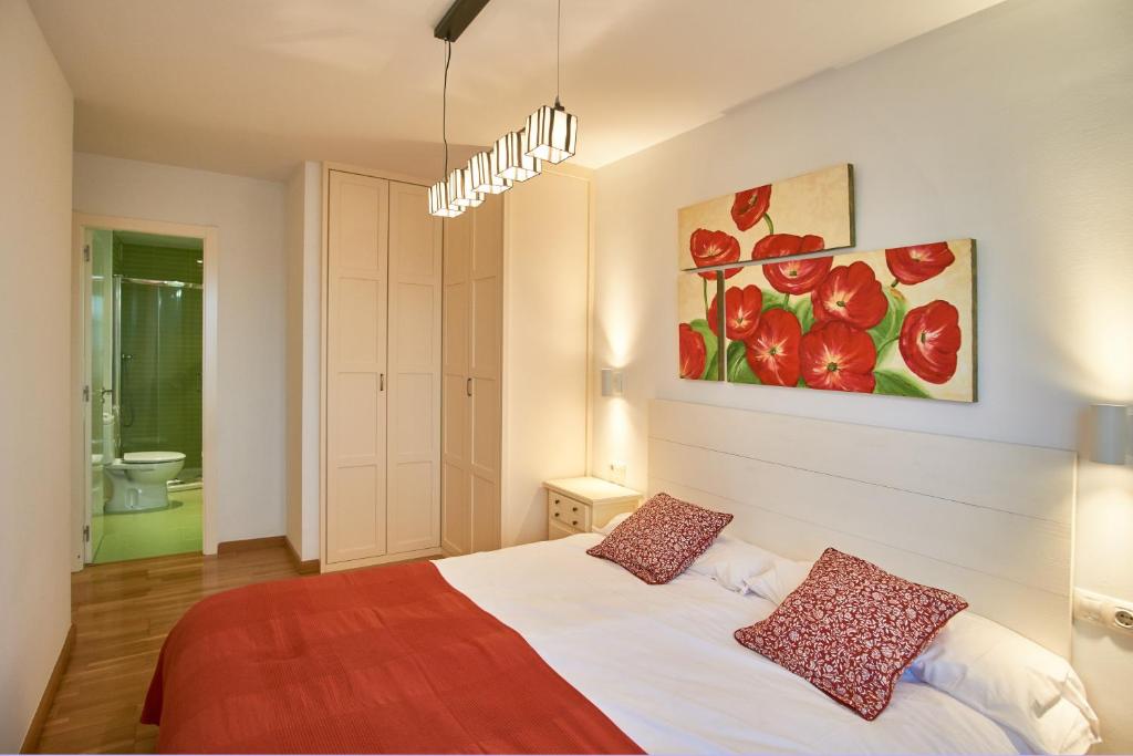 een slaapkamer met een bed en een schilderij aan de muur bij Apartamento Mercado Viejo in Ponferrada