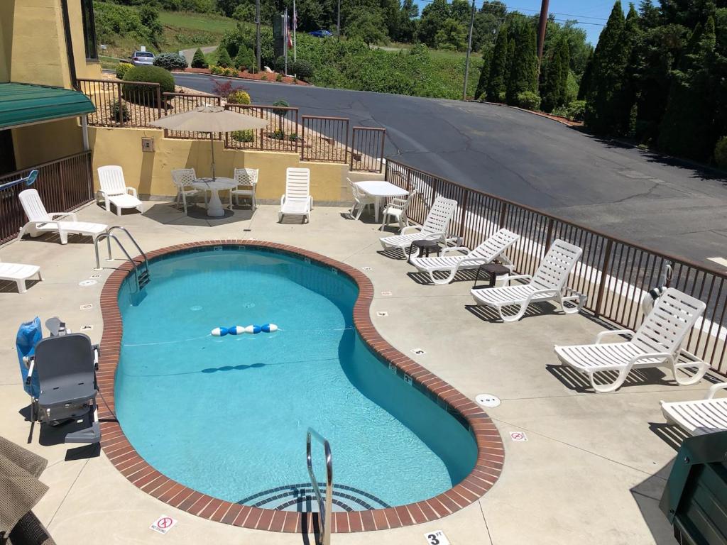 a swimming pool with lounge chairs and a table at Quality Inn in Hillsville