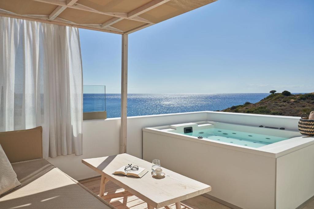 PaliochoriにあるVolcano Luxury Suites Milos - Adults Onlyの海の景色を望む客室で、ホットタブが備わります。