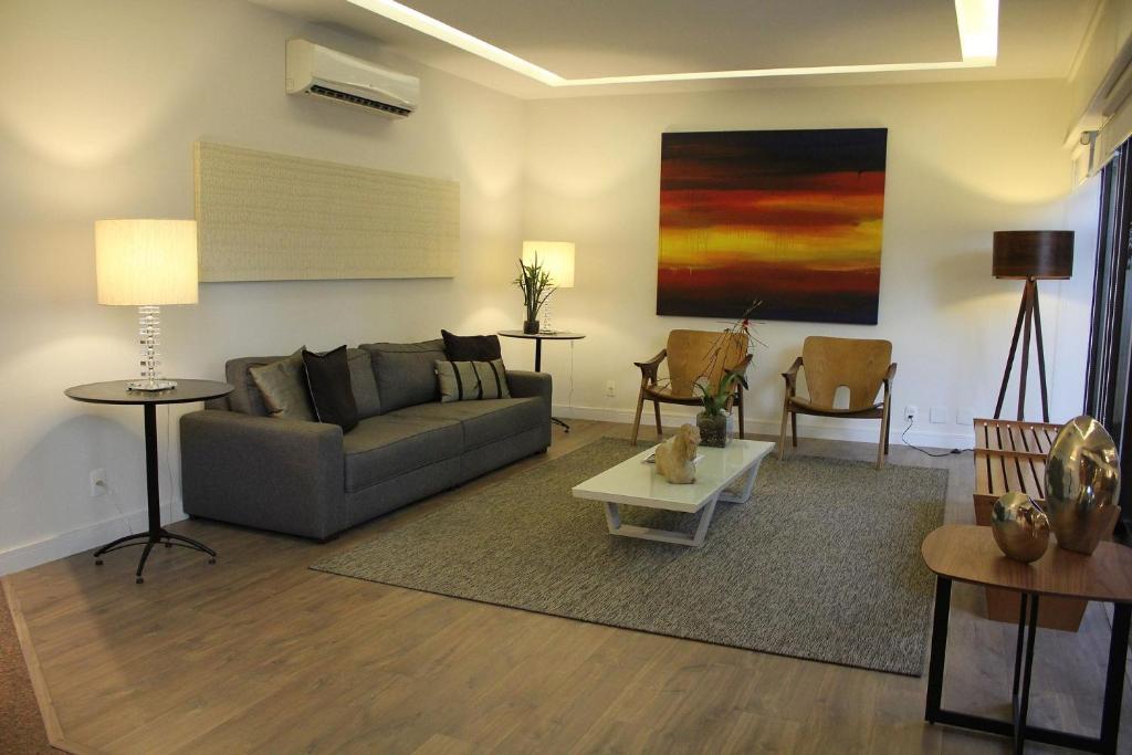 ein Wohnzimmer mit einem Sofa und einem Tisch in der Unterkunft Mc Flats Leblon Inn in Rio de Janeiro