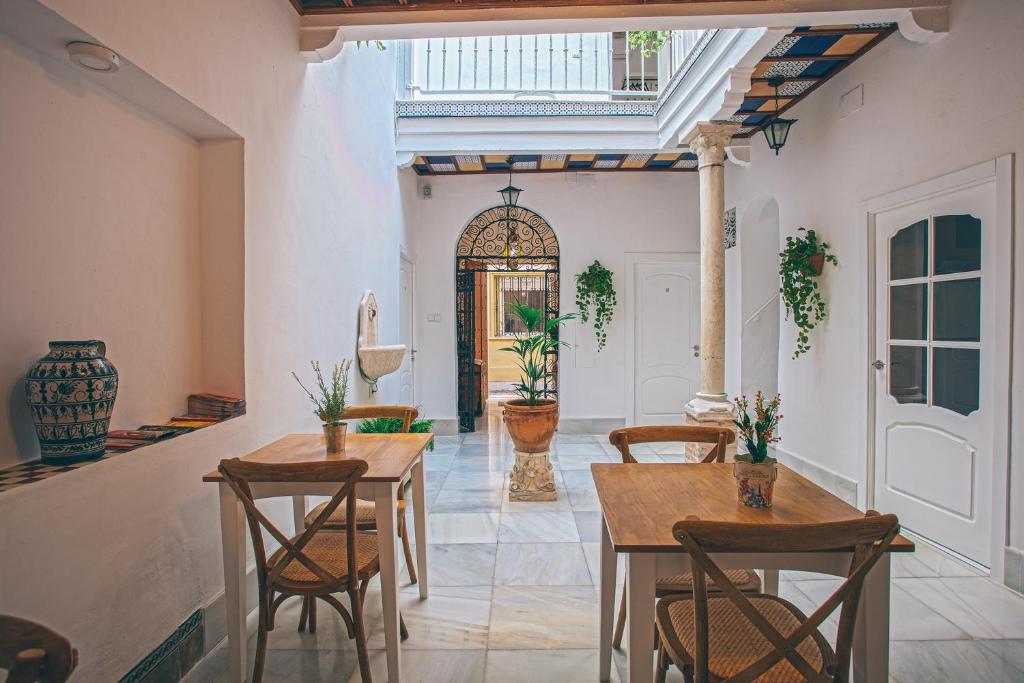 uma sala de jantar com mesas e cadeiras e uma porta em Alcázar de María em Sevilha