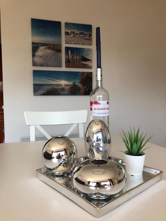 a bottle of wine and two silver dishes on a tray at Sea 2 in Middelkerke