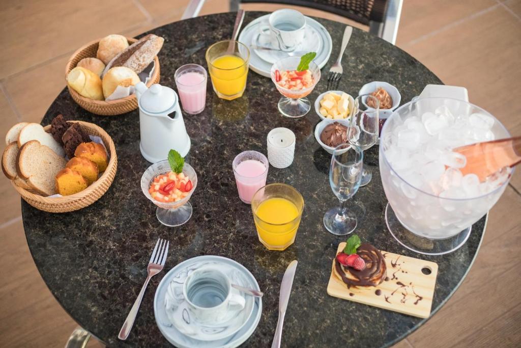 a table topped with plates of food and drinks at Del Rey Quality Hotel in Foz do Iguaçu