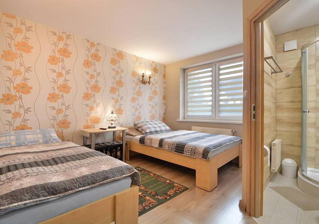 シュチルクにあるPokoje Aleksanderのベッドルーム1室(ベッド2台、窓付)