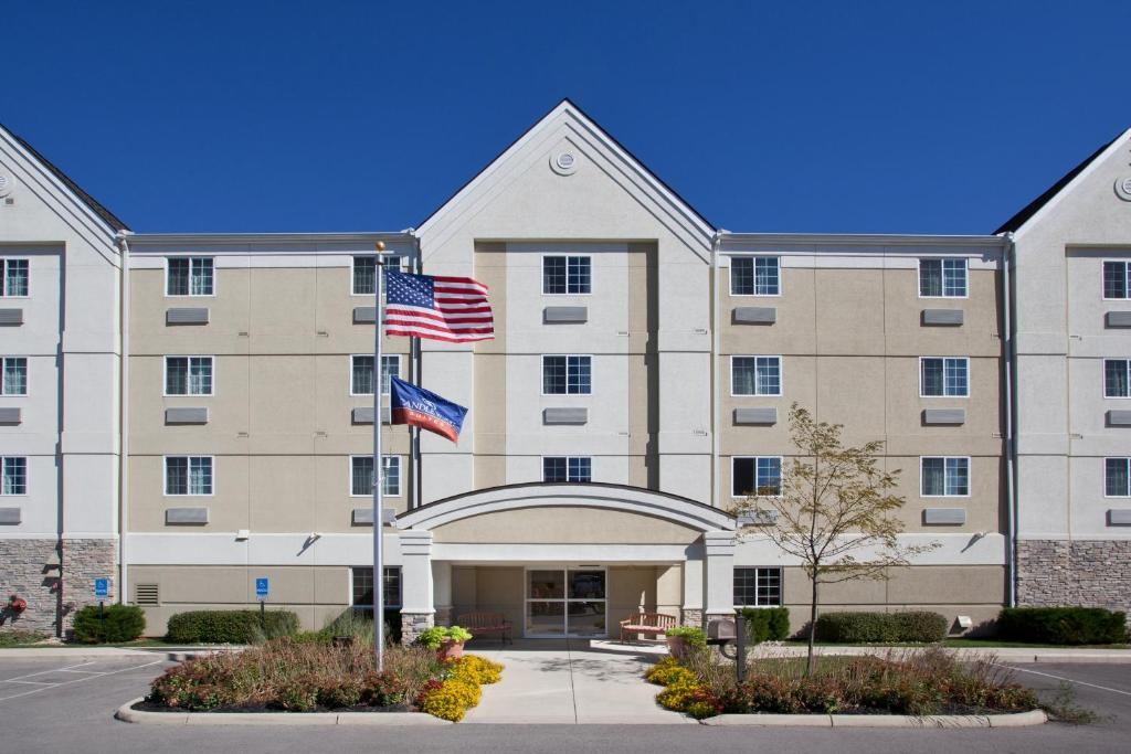 an exterior view of a hotel with two american flags at Candlewood Suites Polaris, an IHG Hotel in Columbus