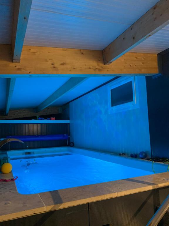 una gran piscina en una habitación con iluminación azul en Gite 5 pers avec 2h espace bien-être privatisé inclus dans le prix de la nuit 80m2 de détente, en Équilly
