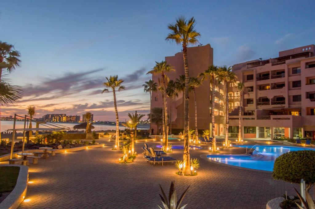 a resort with a pool and palm trees and lights at Marina Pinacate Villa-12 in Puerto Peñasco