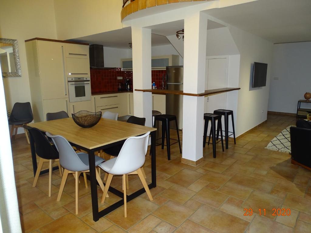 エトワール・シュル・ローヌにあるVilla LA BELLE ETOILEのテーブルと椅子のあるキッチンとダイニングルーム