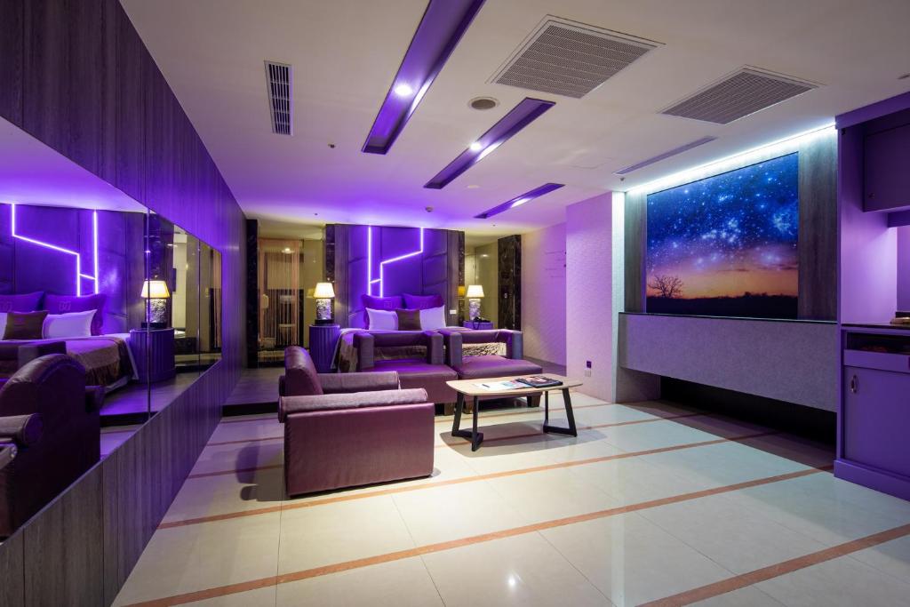 台北的住宿－探索汽車旅館-南港館，紫色的客厅配有沙发和桌子