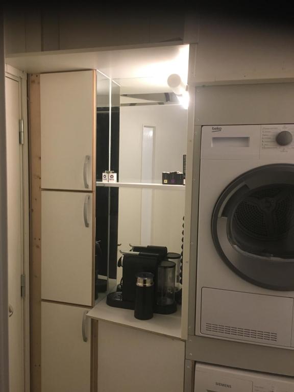 uma cozinha com um micro-ondas e uma máquina de lavar roupa em Studio1 em Tromsø