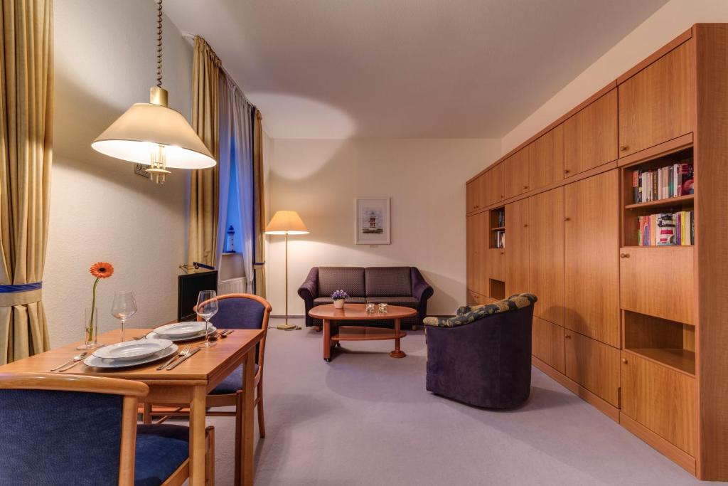 a living room with a table and a couch at Hotel Aquamarin in Kühlungsborn